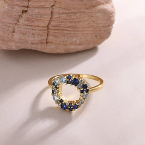 Detail of 18K gold plated ring featuring blue zircons set against a natural stone