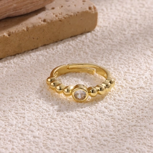 Close-up of gold beaded open ring featuring a sparkling zircon center stone on stone