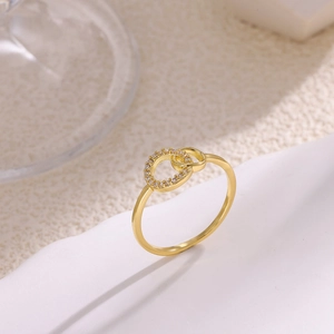 Detalle de cerca del anillo dorado de doble banda entrelazada con pavé de circonitas