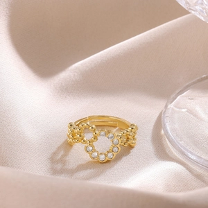 Detail of 18K gold plated bow ring with white zircon flower on beige satin fabric