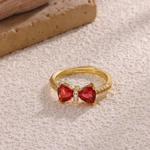 Detail of red heart zircon bow ring with 18K gold plating and adjustable band