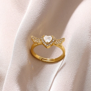 Detailed macro view of heart zircon ring with angel wing design in 18K gold finish