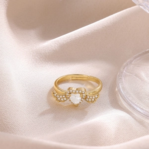 Detail of 18K gold plated heart zircon ring with pavé bow wings and open band design