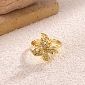 Macro detail of 18K gold plated bow ring with sparkling zircons and open design