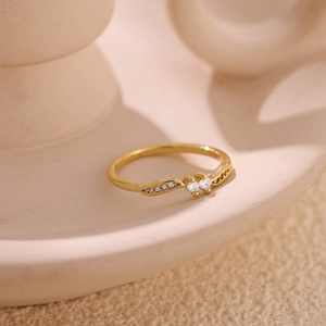 18k gold plated wave ring with double zircon stones on a minimalist cream background