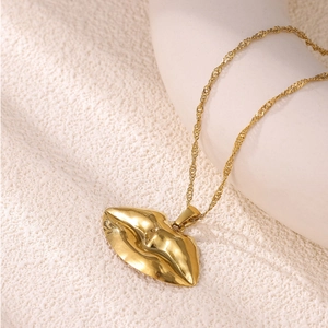 Dettaglio della collana con ciondolo a cuore in oro 18 carati e texture metallica lucida