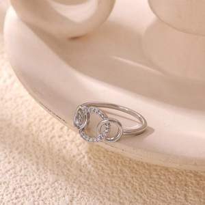 Detailed view of silver triple interlocking ring with paved cubic zirconia stones