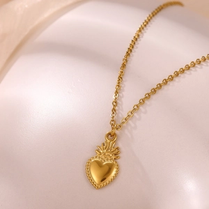 Dettaglio del ciondolo Sacro Cuore dorato 18k con rifiniture vintage in rilievo