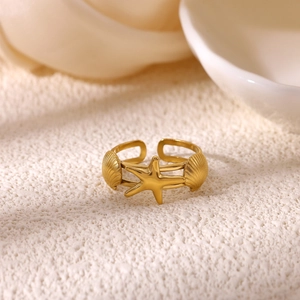 Detailed macro of 18K gold star and shell ring with intricate texture and open band