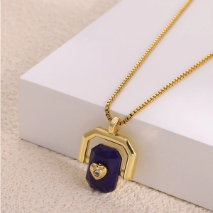 Detailed macro view of the gold box chain necklace and purple octagonal stone pendant