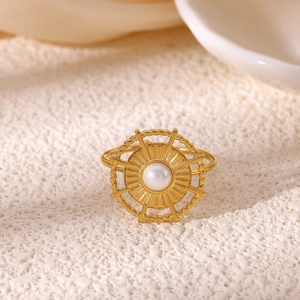 Detail of 18K gold ring featuring a faux pearl and vintage sunburst geometric design