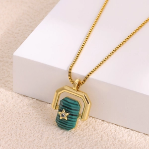Close-up of hexagonal spinning pendant with green malachite stone and gold star on chain