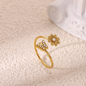 Macro detail of 18K gold open ring with zircon butterfly and small daisy pearl