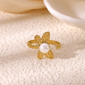 Close-up of 18K gold floral open ring with white round pearl and leaf textures