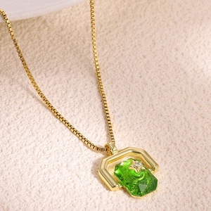 Detailed shot of a gold necklace featuring a rectangular green stone and star motif