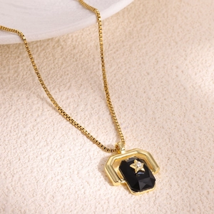 Close-up of golden necklace with black rectangular pendant and zirconia star detail