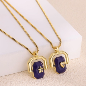 Detail of 18K gold block chain necklaces with purple gemstone pendants and star heart icons