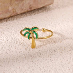 Macro shot of 18K gold plated palm tree ring with green enamel on a sandy background