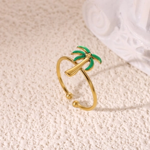 Macro shot of gold plated coconut tree ring with green enamel palm leaves detail