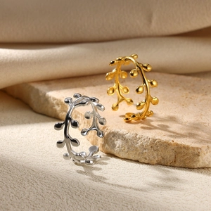 Macro detail of double-layer branch-style rings in gold and silver finish on stone