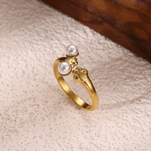 Macro detail of 18K gold flower star ring with white pearls and cat paw motif