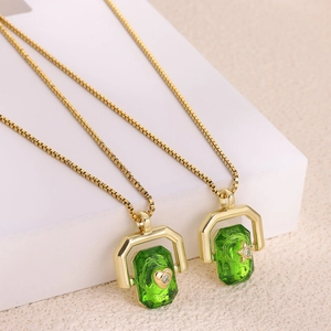Golden box chain necklace featuring green stone pendants with heart and star motifs