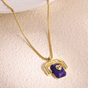 Detailed macro view of a gold box chain necklace with a purple gemstone heart pendant