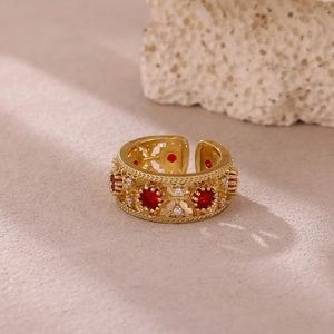 Detalle de anillo vintage bañado en oro con rubí rojo e intrincados patrones calados