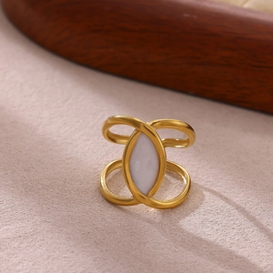 Detalle de un anillo de acero inoxidable dorado con un diseño de incrustación blanca marquesa
