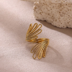 Detalle de anillo de flor chapado en oro con textura martillada y diseño calado