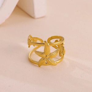 Detailed macro view of gold-plated starfish motifs on a double-layered open ring band