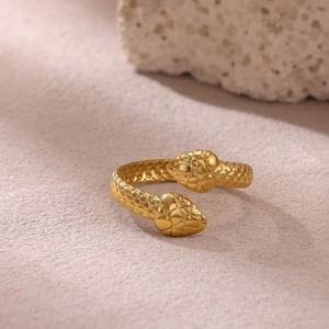Primer plano de un anillo de serpiente dorado de dos cabezas con texturas de escamas finas
