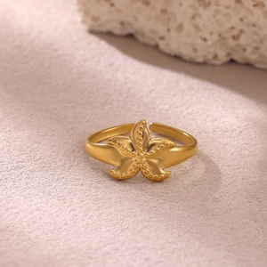 Primer plano macro de un anillo de estrella de mar dorada sobre piedra de coral natural