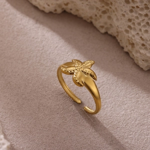 Detalle macro de un anillo de estrella de mar dorada con textura sobre fondo de corales