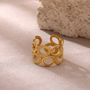 Detalle de anillo calado dorado con bandas ovaladas entrelazadas y textura de cuentas