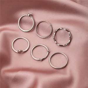 6-teiliges silbernes stapelbares Ring-Set mit minimalistischen Designs auf rosa Seide