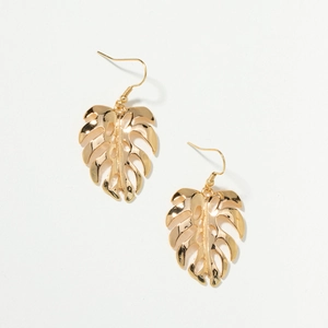 Détail de boucles d'oreilles feuille de monstera dorées avec découpes de style boho