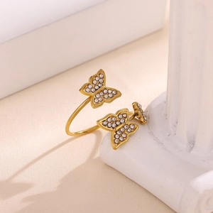 Detalle de anillo abierto de mariposa bañado en oro de 18k con circonitas blancas