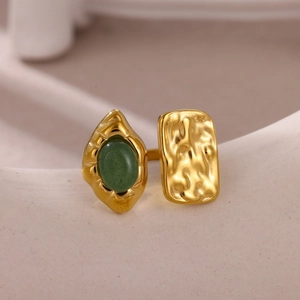 Detail of gold-plated ring showing green stone inlay and hammered metal texture