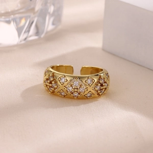 Detalle de anillo chapado en oro de 18k con patrón de rombos y circonitas blancas