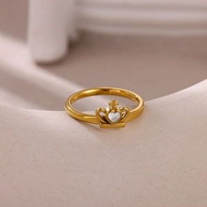 Detail of a gold crown ring with heart-shaped zircon and a small cross motif