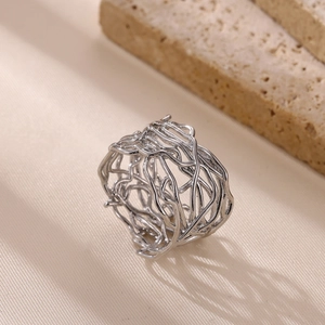 Detailed view of silver stainless steel ring with hollow interwoven artistic lines
