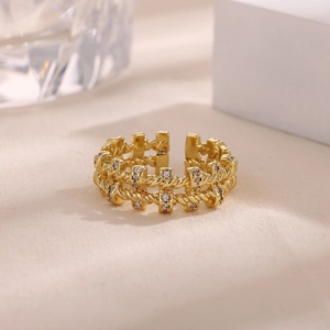 Detalle de anillo trenzado chapado en oro 18k con micropavé de cristales sobre tela