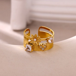 Detailed view of gold plated hollow ring with pearls, zircons and a small heart
