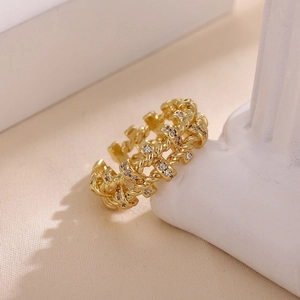 Detalle de anillo de cadena trenzada bañada en oro de 18k con circonitas transparentes