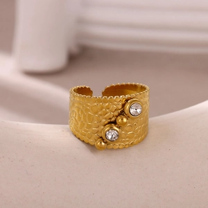 Detailed view of gold plated stainless steel wide ring with hammered texture and zircon
