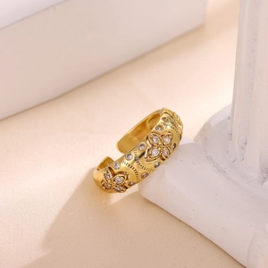 Detalle de anillo ajustable bañado en oro de 18k con diseño de trébol y circonitas brillantes