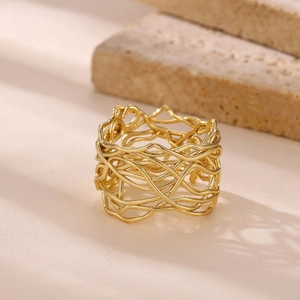 Close-up of golden wide band ring with irregular hollow woven metal line design