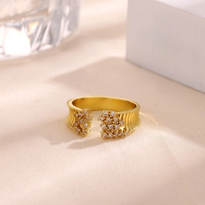Detalle de anillo ajustable dorado con pavé de circonitas sobre fondo de tela crema