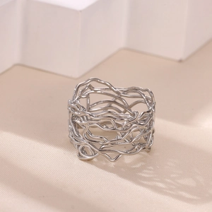 Macro detail of irregular hollow silver ring on satin background with artistic texture